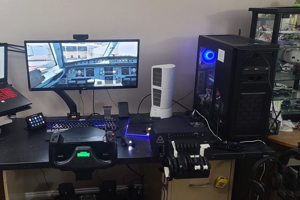 Home flight simulator desk with a yoke, throttle quadrant, monitor showing an airliner cockpit and a gaming PC