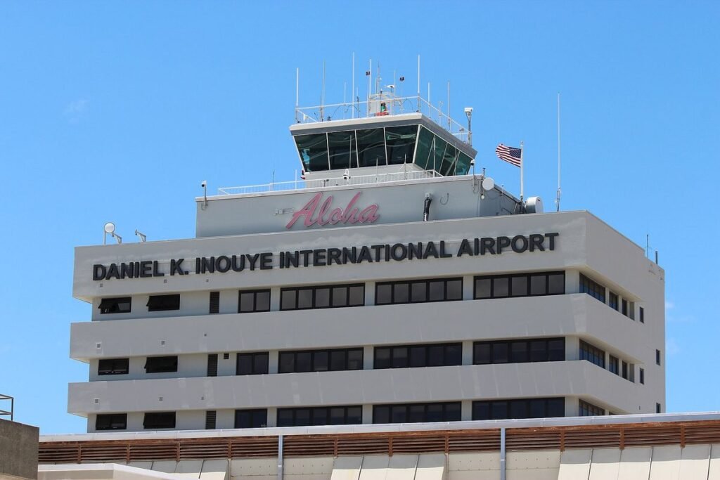 Air traffic control tower cab on top of the terminal building at Honolulu airport under a clear blue sky